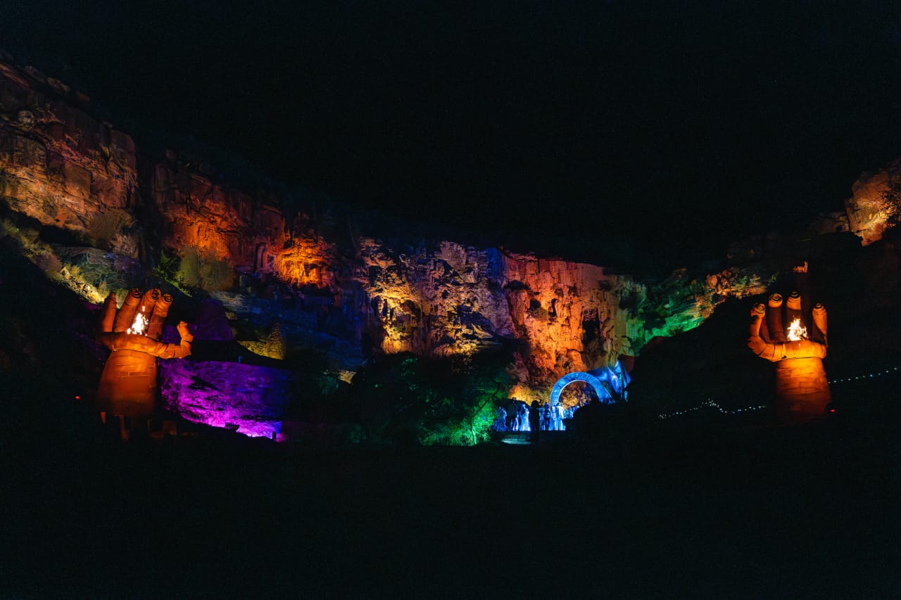 Canyon at night with colorful lighting and fire sculptures